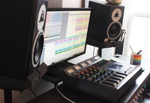 Ljudstudio med mixerbord, bildskärm och två stora monitorhögtalare